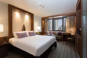 曼谷The Sukosol Hotel的卧室配有一张白色大床和一张书桌