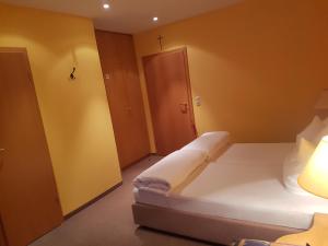 利特曾多夫Gasthof Krapp的卧室配有白色的床和黄色的墙壁