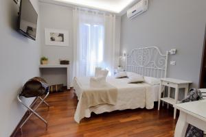 罗马贝佳斯行政套房酒店的白色卧室配有床和桌子