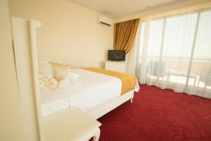曼加利亚MSR Port Hotel的酒店客房,配有床和电视