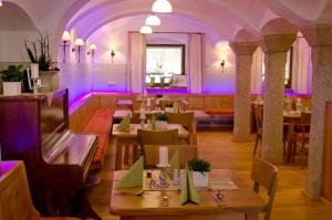 Bärnau祖尔博斯特旅馆酒店的餐厅配有桌椅和紫色照明