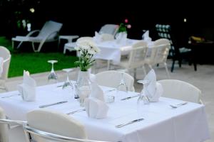 布德瓦Hotel Sanja former Oliva的一组白色桌子,上面摆放着白色椅子和鲜花