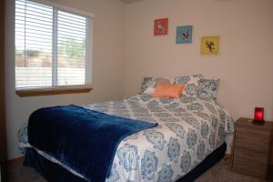 博伊西8635 Ustick Road Apartment的一间卧室配有一张带蓝色和白色棉被的床