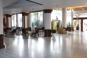 芭堤雅市中心芭提雅迎宾广场酒店的空的大堂设有桌椅和窗户