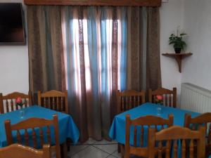 斯科拉埃菲酒店的用餐室配有2张桌子和椅子以及窗帘