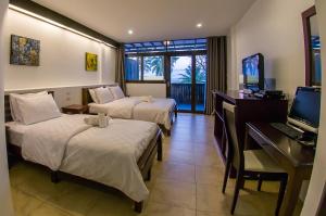 跋麒班塔勒腾轮酒店的酒店客房设有两张床、一张桌子和一台电视。