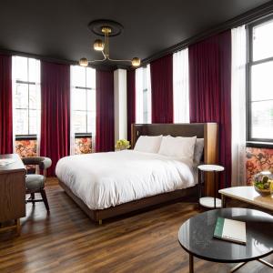 多伦多布罗德维尤酒店的一间卧室配有一张带红色窗帘的大床