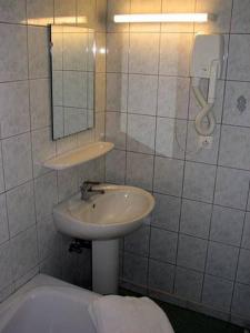 Wildenstein乐索尔酒店的浴室配有盥洗盆、镜子和浴缸