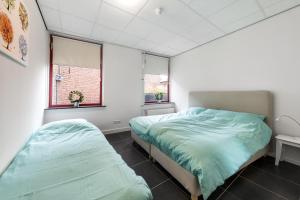 OudewaterVakantieappartementen centrum Oudewater的一间卧室设有两张床和两个窗户。