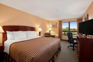 尤蒂卡尤蒂卡戴斯酒店的配有一张床和一台平面电视的酒店客房