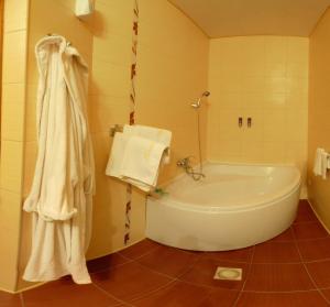 赫梅利尼茨基兴特拉尔尼酒店的浴室配有浴缸、淋浴和毛巾。