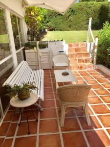 EsteponaEstudio a 10 minutos del Puerto Banus的庭院设有长凳和桌椅。