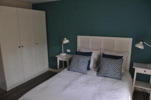 绍莱Au Rez de Jardin的卧室配有白色床和蓝色的墙壁