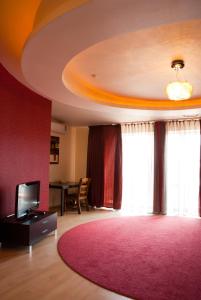 赫梅利尼茨基兴特拉尔尼酒店的客厅配有粉红色地毯和电视