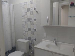 弗洛里亚诺波利斯Casas Adilio Florianopolis-norte的一间带卫生间、水槽和镜子的浴室