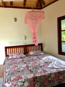马特勒Seasons Four Mini Jungle Cabana的一间卧室配有一张带粉红色窗帘的床