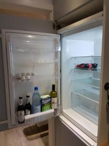 弗里茨拉尔Ferienwohnung Oliver的配有瓶装葡萄酒和牛奶的开放式冰箱