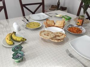 努沃勒埃利耶佩雷拉民宿的餐桌,盘子上放着食物,香蕉和面包
