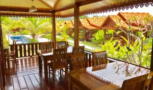 华欣泰国度假酒店的餐厅的门廊上设有木桌和椅子
