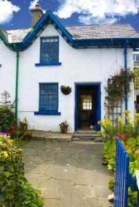 纽卡斯尔Slieve Donard Cottage Widows Row cottages的白色的房子,有蓝色的窗户和门