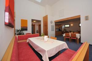Sankt Georgen裴森瓦尔德霍夫疗养院酒店的餐厅配有白色桌子和红色椅子