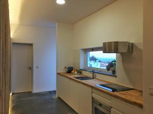 英雄港Casa do Pisão - Cosy and Modern Two-Bedroom Townhouse的厨房设有水槽和窗户。