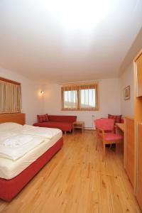 Sankt Georgen裴森瓦尔德霍夫疗养院酒店的一间卧室配有一张床、一张沙发和一张桌子
