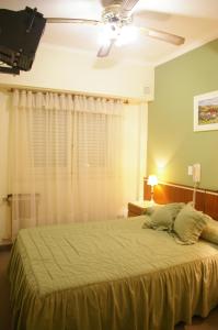 马德普拉塔科姆波斯特拉酒店的一间卧室配有一张大床和吊扇