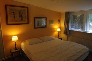 WestermientDe Boem的卧室配有白色的床和两盏灯。