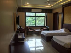 王舍城Indo Hokke Hotel的酒店客房设有两张床和窗户。