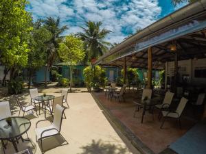 通萨拉海门海滩度假村的一个带桌椅的庭院,棕榈树