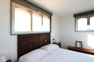 卡尔伦蒂尼扎哈拉乡村民宿的一间卧室设有2扇窗户和一张带白色床单的床