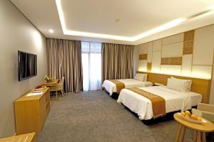 三宝垄Patra Semarang Hotel & Convention的酒店客房配有两张床和一张书桌