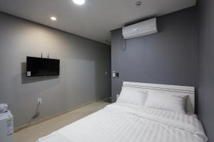 釜山O'guest in Haeundae的卧室配有白色的床和电视