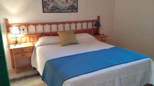 圣费兰-德瑟斯罗Can Xumeu Miquel的一间卧室配有一张白色的床和蓝色的毯子