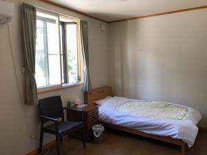 仙北角馆优雅旅馆的卧室配有床、椅子和窗户。
