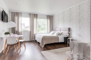 肯佩莱Apartment Kievarinhovi的白色卧室配有床和桌椅