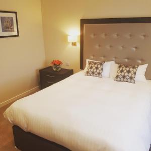 邓甘嫩科汉诺旅馆的卧室配有一张白色大床和床头板