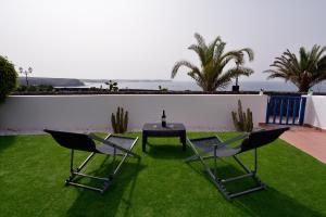 普拉亚布兰卡Villa Vista Mar的草地上带桌椅的天井
