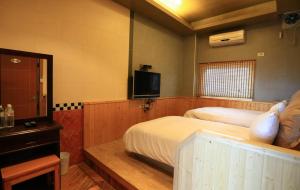 万里区万里仙境温泉会馆 的酒店客房设有两张床和电视。