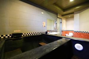 万里区万里仙境温泉会馆 的一间带水槽和镜子的大浴室