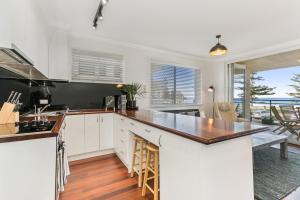 悉尼黄金英里海滨公寓的厨房配有白色橱柜和台面