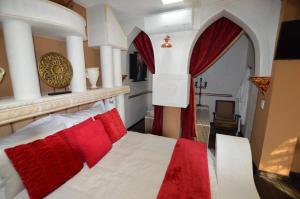 约翰内斯堡Kiwara Guesthouse的卧室配有带红色枕头的白色床