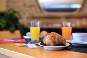 阿尔盖罗Double B Maison De Charme的一张桌子,上面放着一盘食物和两杯橙汁