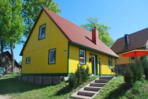 ZislowFerienhaus Zislow am Plauer See的红色屋顶的黄色房子