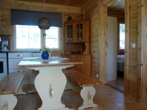 SysmäCottage Kivitatti的小屋内的厨房配有桌子和长凳