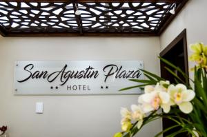 拉塔昆加Hotel San Agustin Plaza的花卉墙面上的圣伊格纳西奥酒店标志