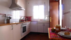 丰特-德彼德拉Lagunilla Rural的厨房配有白色橱柜、窗户和桌子