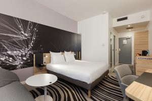 图尔诺富特旅游中心火车站酒店的酒店客房带一张床、一张桌子和椅子