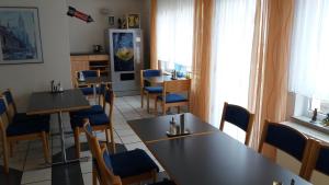AlthengstettMotel Am Highway的一间配备有桌子和蓝色椅子的用餐室
